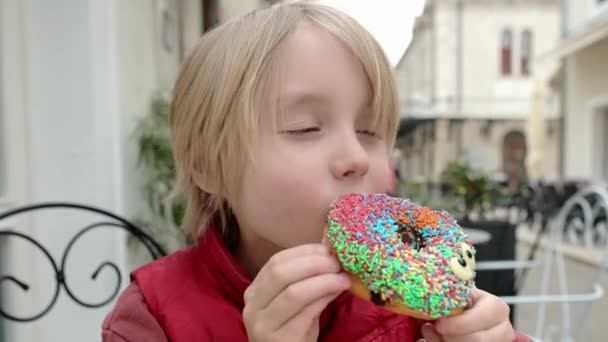 Leuke School Leeftijd Jongen Eten Grappige Kleurrijke Donut Een Straat — Stockvideo