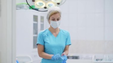 Kadın cerrah tıbbi koruyucu eldivenler giyer. Doktor ameliyathanede ameliyata hazırlanıyor. Sağlık sigortası. İlaç ve sağlık hizmetleri.
