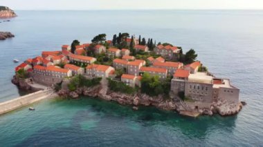 Tarihsel kenti olan Sveti Stefan adasının inanılmaz günbatımı hava aracı görüntüsü. Montenegro 'da yer alan Adriyatik Denizi' nin en aşağı manzarası. Balkan 'da ünlü turistik ilgi odağı..