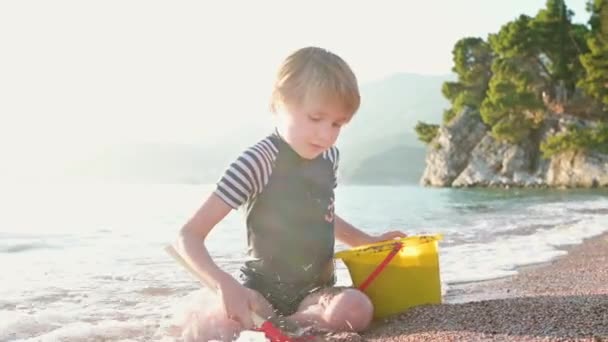 Criança Feliz Brincando Com Areia Pedras Sentadas Praia Menino Alegre — Vídeo de Stock