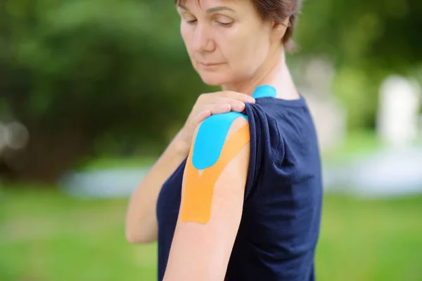 肩膀上系着运动学带子的女人方法的目的是减轻运动损伤和各种其他身体紊乱造成的疼痛和残疾 运动学 — 图库照片