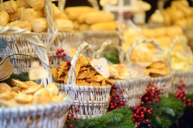 Traditional Poland street food oscypek is a grilled cheese of salted sheep milk with different ingredients as bacon or jams. Basket of oscypek on Christmas market in Krakow. Local polish cuisine.