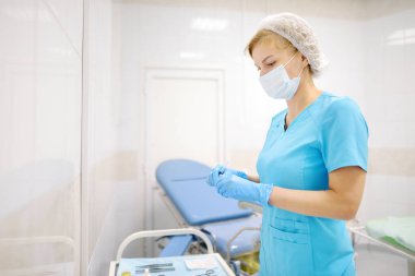 The female surgeon is dialing medicine into a syringe. Doctor is preparing to give an injection to the patient in operation room. Medicine and healthcare.