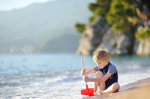 Szczęśliwe Dziecko Bawiące Się Piaskiem Kamieniami Siedzące Brzegu Morza Radosny — Zdjęcie stockowe