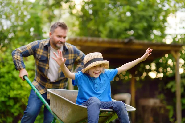 Happy Little Boy Having Fun Wheelbarrow Pushing Dad Domestic Garden — Stock fotografie