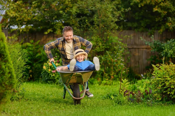 Happy Little Boy Having Fun Wheelbarrow Pushing Dad Domestic Garden — Stockfoto