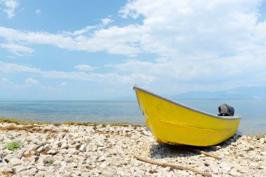 Yellow motor boat on shore of wonderful Skadar lake on the background of mountains. Giant Skadar Lake is a famous bird nature reserve in Balkans located in Albania and Montenegro. Travel and tourism.