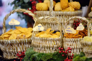 Traditional Poland street food oscypek is a grilled cheese of salted sheep milk with different ingredients as bacon or jams. Basket of oscypek on Christmas market in Krakow. Local polish cuisine.