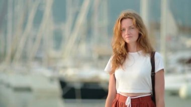 Akdeniz kıyısındaki çekici genç turist kadının portresi. Deniz kıyısında yürüyen çekici kızıl saçlı bir kız. Doğal güzellik kavramı