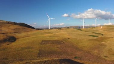 Yenilenebilir enerji üretimi için enerji santrallerinin insansız hava aracı videosu. Güneşli yaz gününde yel değirmenleri. Jenerasyon elektriği için yüksek rüzgar türbinleri. Yeşil enerji kavramı.