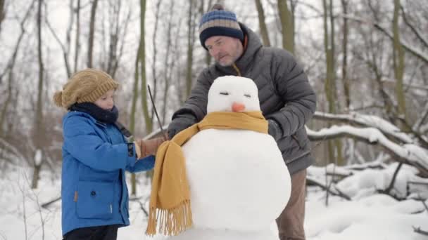 눈덮인 공원에서 아버지와 스노만을 아버지와아 질높은 시간을 보냅니다 겨울에는 야외에서 — 비디오