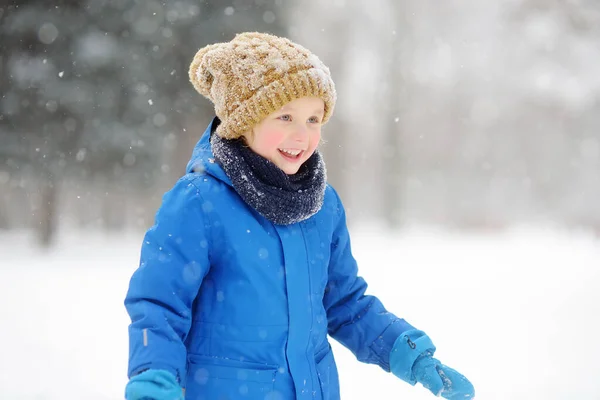 雪の中で新雪と遊ぶのが楽しい男の子 赤ちゃんは手袋に雪の結晶をキャッチ 暖かい服 手の手袋 スカーフで身を包んだ子供 子供のためのアクティブな冬の屋外レジャー — ストック写真