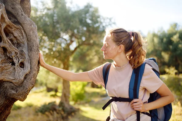 Young woman hiking in countryside. Concepts of adventure, extreme survival, orienteering. Single travel. Backpacking hike Forest protection and restoration in Europe.