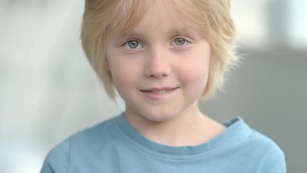 Charming Blond Boy Looks You Folds His Hands Shape Heart — Stock Video