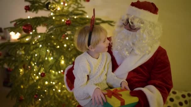 Dojrzały Ojciec Przebrany Świętego Mikołaja Rozmawia Swoim Synkiem Siedzącym Przy — Wideo stockowe