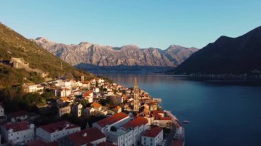Antik Perast, Montenegro kentinin panoramik günbatımı drone görüntüsü. Arka planda kırmızı çatıları ve görkemli dağları olan eski bir ortaçağ kasabası. Adriyatik Denizi kıyısında resim gibi Kotor Körfezi..