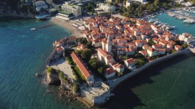 Karadağ 'ın antik Budva kentinin panoramik gün batımı drone görüntüsü. Kırmızı çatıları olan eski bir ortaçağ kasabası. Adriyatik Denizi kıyısındaki Picturesque Kotor Körfezi. Budva, Karadağ 'ın en popüler tatil beldesi