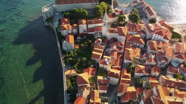 モンテネグロのブドヴァの古代都市のパノラマの夕日の空中ドローンビュー 赤い屋根の古い中世の町 絵のようなコトル湾 アドリア海の海岸 ブドヴァはモンテネグロで最も人気のあるリゾートタウンです — ストック動画