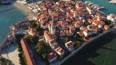 Karadağ 'ın antik Budva kentinin panoramik gün batımı drone görüntüsü. Kırmızı çatıları olan eski bir ortaçağ kasabası. Adriyatik Denizi kıyısındaki Picturesque Kotor Körfezi. Budva, Karadağ 'ın en popüler tatil beldesi