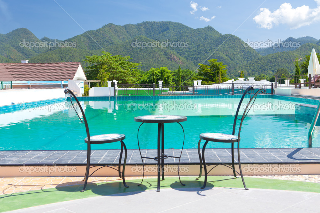 Table and chairs besides mountains