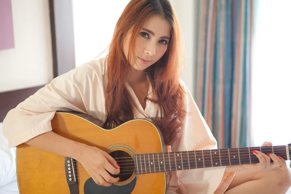 Jovem mulher tocando guitarra — Fotografia de Stock