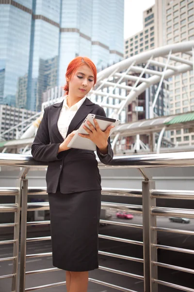 Vrouw met tablet op moderne stad — Stockfoto