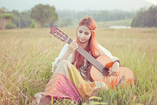 Hippie flicka spela gitarr på gräs — Stockfoto