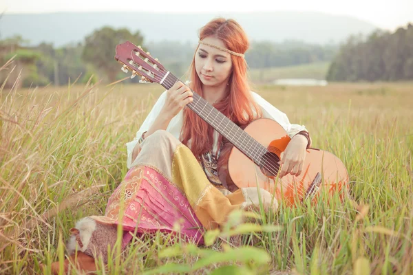 Hippi kız çimenlerin üzerinde gitar çalmak — Stok fotoğraf