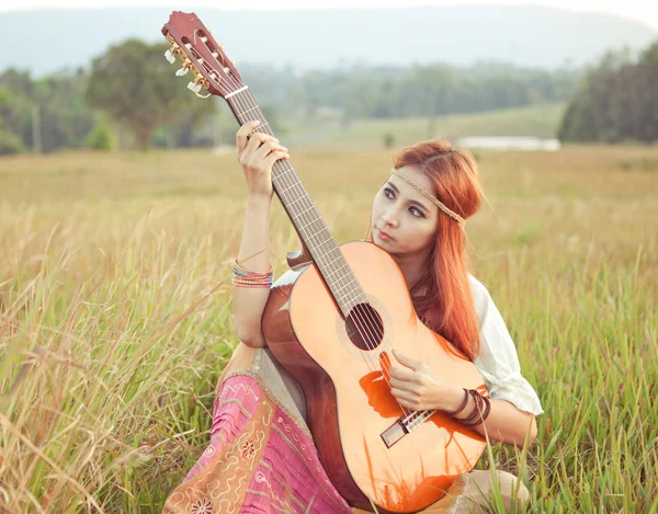 Hippi kız çimenlerin üzerinde gitar çalmak — Stok fotoğraf