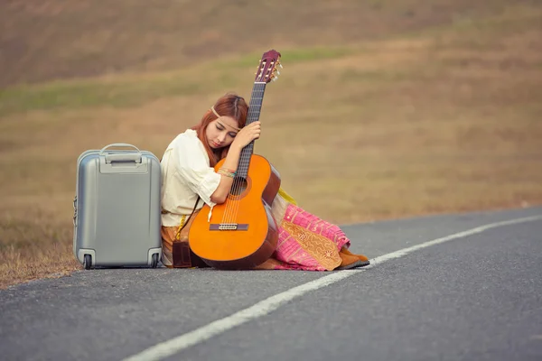 Hippie mulher sentada em uma estrada rural — Fotografia de Stock