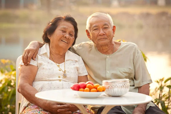 Happy Senior couple sitting outdoors — Stock Photo, Image