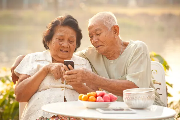 Pareja mayor usando el teléfono móvil Fotos de stock libres de derechos