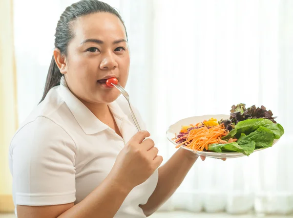 Толстая женщина ест салат — стоковое фото