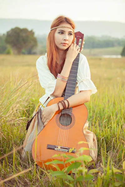 Hippie meisje gitaar spelen op gras — Stockfoto