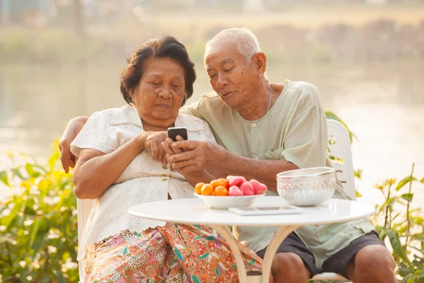 Pareja mayor usando el teléfono móvil — Foto de Stock