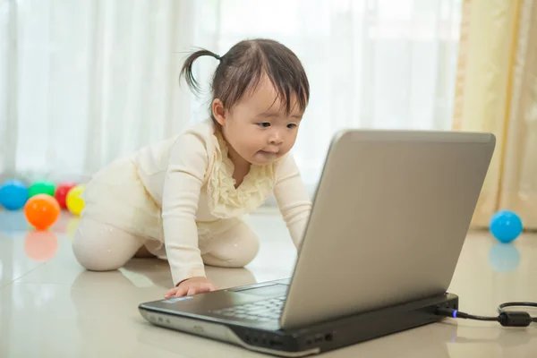 Mały azjatycki girl Zagraj laptopa w domu — Zdjęcie stockowe