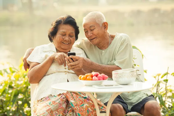 Casal sênior usando o telefone celular — Fotografia de Stock