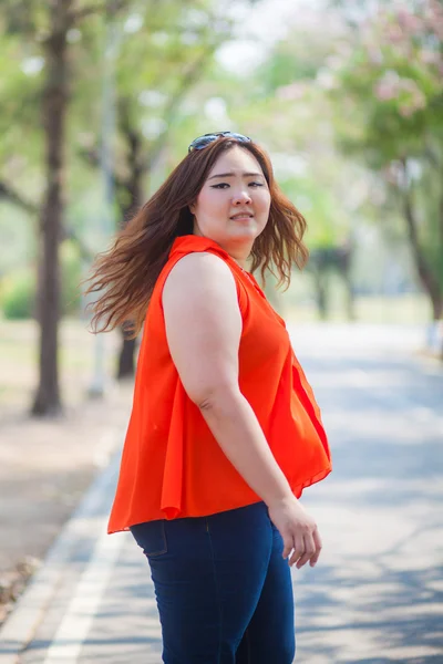 Onnellinen lihava nainen poseeraa ulkona — kuvapankkivalokuva