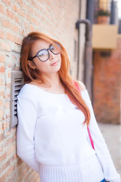 Beautiful asian woman with stone wall — Stock Photo, Image