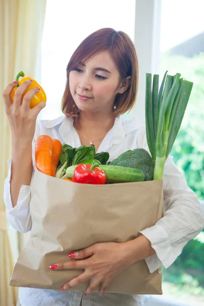 Young Woman with vegetables in shopping bag
