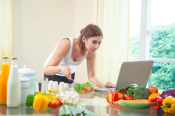 Junge asiatische Frau auf der Suche nach einem Rezept — Stockfoto