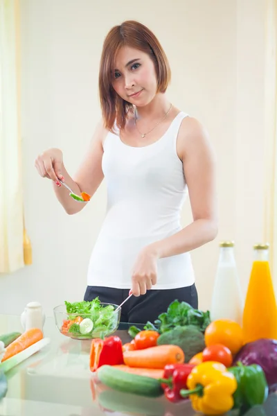 Mujer feliz cocinando verduras ensalada verde — Foto de Stock