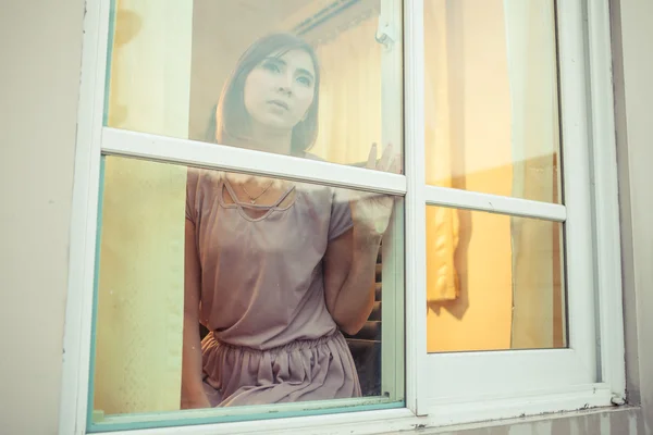 Genç Asyalı kadın pencerede üzücü — Stok fotoğraf