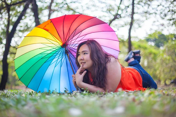 Счастливая толстая женщина с зонтиком — стоковое фото