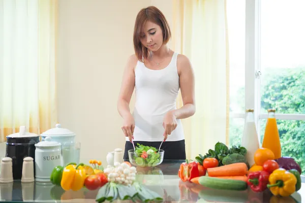 Mujer feliz cocinando verduras ensalada verde —  Fotos de Stock