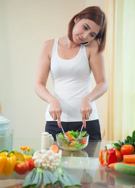 Young asian woman in kitchen and talking on the mobile phone — Stock Photo, Image