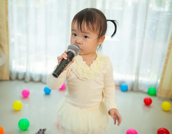 Liten asiatisk jente med mikrofon – stockfoto