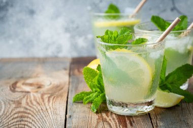 İki bardak limonata ya da naneli mojito kokteyli soğuk, ferahlatıcı içecek ya da buzlu, mavi arka planda buzlu içecek. Boşluğu kopyala