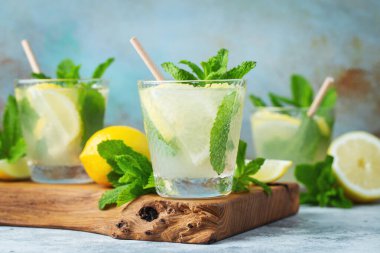 İki bardak limonata ya da naneli mojito kokteyli soğuk, ferahlatıcı içecek ya da buzlu, mavi arka planda buzlu içecek.