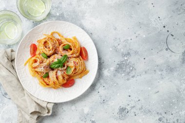 Lezzetli iştah açıcı klasik İtalyan tagliatelle makarnası domates soslu, peynirli parmesan peyniri ve tabakta fesleğen. Yukarıdan bak, yatay. Kopyalama alanı olan üst görünüm